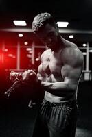 idrottare stark sportig kroppsbyggare. stilig muskulös man Framställ i de Gym. foto