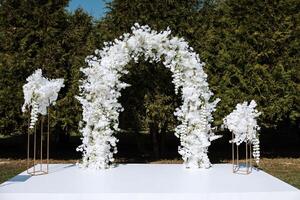 dekor på de bröllop. ett oval båge dekorerad med vit blommor foto