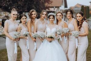 bröllop fotografi. en brunett brud i en vit klänning med en bukett och henne brunett flick foto