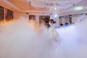 de först dansa på de bröllop av de brud och brudgum i ett elegant restaurang med bra belysning och atmosfär. tung rök foto