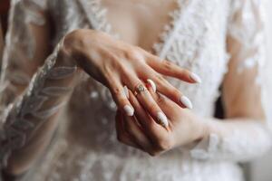 närbild av ett elegant diamant ringa på en kvinnas finger med en modern manikyr, solljus. kärlek och bröllop begrepp. mjuk och selektiv fokus. foto
