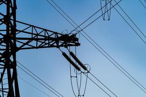 elektricitet pylon med trådar under hög Spänning. landskap med högspänning överföring torn. blå himmel bakgrund. foto