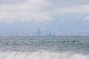 skön bris från de vågor av de hav mot de bakgrund av de stad. foto