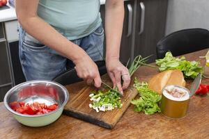 hacka de grön lök och tomater och plats dem i en skål. förbereda de sallad. foto