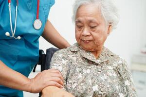 läkare hjälp asiatisk äldre kvinna handikapp patient Sammanträde på rullstol i sjukhus, medicinsk begrepp. foto