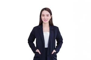ung asiatisk professionell arbetssätt affärskvinna bär svart kostym Framgång stående ficktjuv och leende på arbete kontor lyckligt medan isolerat vit bakgrund. foto