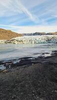 massiv Vatnajokull glaciär keps i island med diamant form stenar och transparent block av is målad vit och blå. nordic frysta kullar täckt i glasera, kall vatten inom isländsk landskap. foto