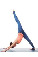 sportig passa yogini kvinna praxis yoga asana eka pada adhomukha foto
