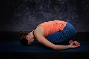 skön sportig passa yogi flicka praxis yoga asana balasana foto