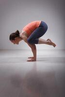 skön sportig passa yogini kvinna praxis yoga asana kakasana foto