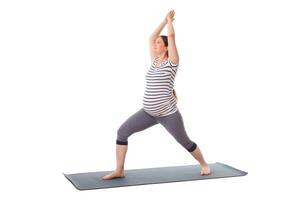 gravid kvinna håller på med yoga asana virabhadrasana 1 foto