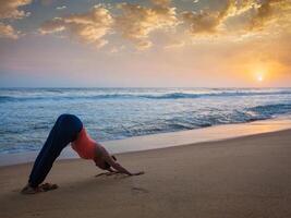 kvinna håller på med yoga surya namaskar oudoors på tropisk strand foto