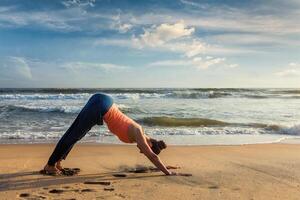 kvinna håller på med yoga surya namaskar oudoors på tropisk strand foto