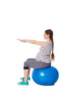 gravid kvinna håller på med övningar med övning boll foto