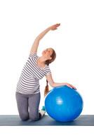 gravid kvinna håller på med övningar med övning boll foto