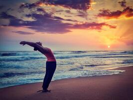 ung sportig passa kvinna håller på med yoga Sol hälsning surya namaskar foto