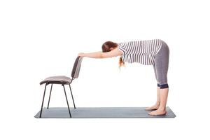 gravid kvinna håller på med yoga asana uttanasana foto