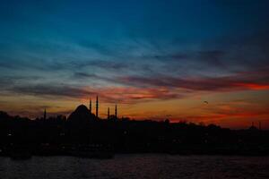 silhuett av istanbul med dramatisk moln på solnedgång. suleymaniye moské foto