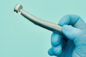 en tandläkare bär handskar i de dental kontor innehar en verktyg innan arbetssätt foto