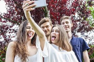 grupp av ung vänner ta en selfie kramade tillsammans foto