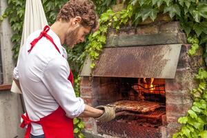 hipster ung man framställning en utegrill fest foto