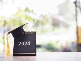 studie mål, 2024 skrivbord kalender med gradering hatt. de begrepp för upplösning, mål, handling, planera, och klara av tid till Framgång examen. foto