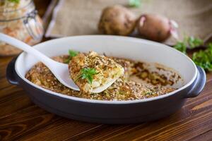 potatis gryta med kål och kryddor i en keramisk form foto