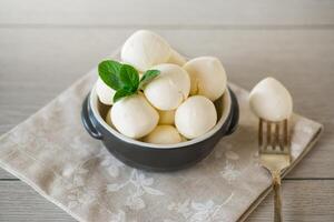 små bollar av traditionell mozzarella i en keramisk skål foto