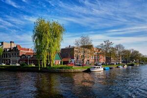 båtar, hus och kanal. harlem, nederländerna foto