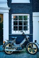 motorcykel parkerad nära gammal hus i amsterdam gata, foto