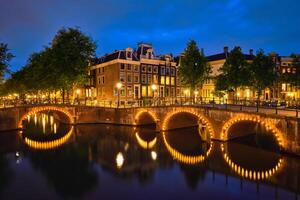 amsterdam kanal, bro och medeltida hus i de kväll foto