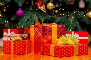 lugg av jul gåva lådor på de golv under skön jul träd foto