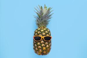 ananas med solglasögon på blå bakgrund foto