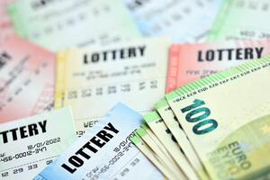 många lotteri biljetter och euro räkningar på tom räkningar med tal för spelar lotteri foto