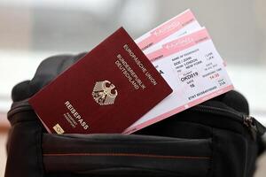 röd tysk pass av europeisk union med flygbolag biljetter på turistiska ryggsäck foto