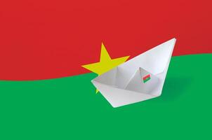Burkina faso flagga avbildad på papper origami fartyg närbild. handgjort konst begrepp foto