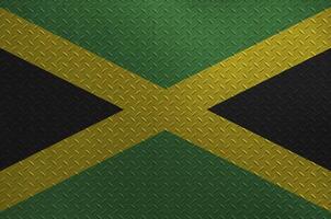 jamaica flagga avbildad i måla färger på gammal borstat metall tallrik eller vägg närbild. texturerad baner på grov bakgrund foto