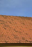 de tak av detta fyrkant keramisk bricka är röd. de gammal typ av tak beläggning i rik hus av de 19:e århundrade foto