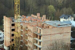 se av en stor konstruktion webbplats med byggnader under konstruktion och flera våningar bostads- hem. hus renovering foto