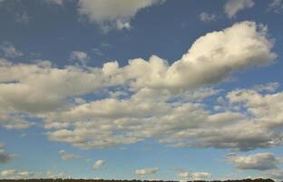 lantlig landskap med en grön fält under en molnig blå himmel foto