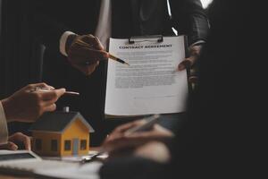 verklig egendom ombud och försäljning chef team analys prissättning av uthyrning hyra kontrakt av försäljning inköp avtal, rörande inteckning lån erbjudande för och hus försäkring. foto