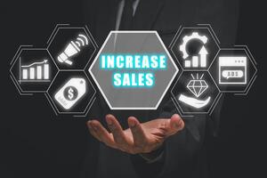 öka försäljning begrepp, affärsman hand innehav öka försäljning ikon på virtuell skärm. foto