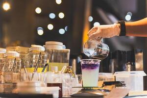 man framställning fjäril te med yuzu juice i en tak bort glasögon. foto