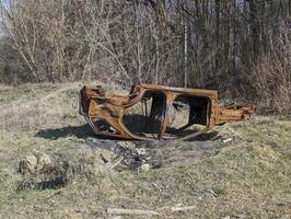 rostig gammal bil upside ner i de vår skog foto
