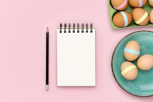 tom anteckningsbok och penna på rosa bakgrund med ägg kartong och tallrik foto
