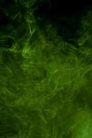 eterisk elegans, mystisk grön rök dans mot en noir duk foto