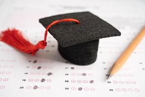 examen gap hatt och penna på svar ark bakgrund, utbildning studie testa lärande lära koncept. foto