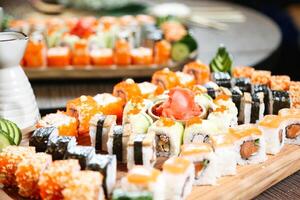 trä- bricka toppade med blandad sushi rullar foto