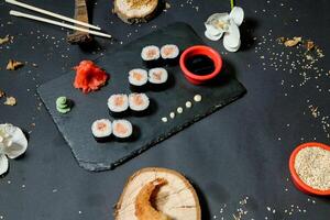 tallrik av sushi med ätpinnar och skål av sås foto