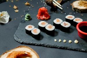 sushi på skiffer styrelse med ätpinnar och sås foto